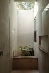The walk-in shower in the primary bathroom has an open-air skylight. “When it’s cold, you can feel it, but then the warm water tempers that,” says Orlando. The hooks are from Proyecta by Helvex.