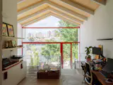On the top floor, the stair culminates at an office that looks out over the terrace. The shelving and cabinetry were designed by Arkitito.