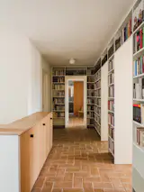 The upstairs hallway features books and a new ceramic tile floor made from local clays.
