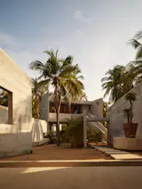 A concrete pathway culminates in a stairway to the fourth villa, the only one that is elevated. Added toward the end of the design process to accommodate an additional owner, it is smaller than the others and more sparsely furnished, with only one bed in the bedroom.
