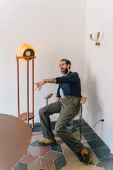 Designer Mario Milana of Casa Milana walked us through his Brera home. The floor lamp to his left produces both directional and ambient light, and is supported by a metal frame.