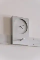 A clock by Elora and Andrew plays off one by the Shakers, which had a similar peg-mounted form, though made from wood. Here, along with the material departure, the designers also applied a ledge that allows their version to prop above the peg system, rather than hang below it like its historic counterpart.