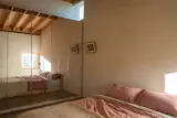 The bedroom has mirrored closets, making it feel more open.