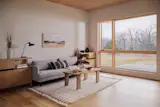The living room is flooded with natural light. "The Marvin windows are pine, and they have a beautiful yellow hue that ties very nicely to the cedar," says architect Josh Carel. "So they had that as a starting point to build the material palette from."