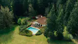 Set beyond a gated drive, the 35-acre property has a pool, a barn, and an apple orchard, plus a backstory featuring cows, friars, and an owner-builder with a thing for arches.
