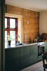 The kitchen cabinets are from Ikea, with fronts made by Friso. They are painted green with linseed oil paint.