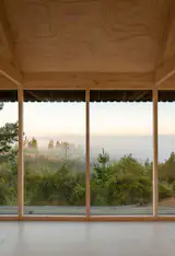 The design was meant to complement the striking views of the forested hills—and the Pacific a mile away—through a wall of minimally framed glass panes spanning the cabin’s front. “Whenever I arrive, I sit on the sofa and stay there for a while, gazing at the horizon,” says Raúl.