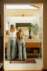 It was hard for the Skobys to find the right cabinetry for the main bathroom. Coyote Custom Woodwork was willing to build the custom vanities in exchange for some of Joe’s art.