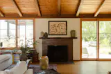 The fireplace is a centerpiece of the open living area. The Skobys splurged on the Heath Ceramics tiles on its front; the square hearth tiles are limestone from Ann Sacks. The painting is by artist Philippine des Richemont, and is flanked by some of Joe’s pieces. Joe’s cousin, Evan Chambers, a glassblower in Altadena, made the lamp by the window..