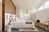 The primary suite was converted from the original carport by a previous owner and features wood slat detailing, clerestory windows, an ensuite bathrom, and a walk-in closet.