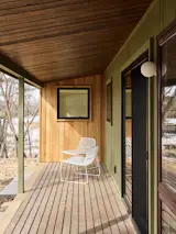 The raised, covered porch is reminiscent of a Japanese <i>engawa</i>, a veranda-like transitional space that connects the home to the landscape. The renovation expanded views to the lake with new windows in the primary bedroom and bath, and sliders that replaced a standard solid door in the living area.