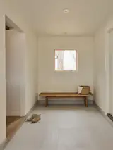 Inspired by the Japanese <i>genkan</i>, or entry sequence, the new mudroom replaced what had been a breezeway between the house and the detached garage. A bench built by Wes sits beneath a small window that reflects the home’s broader embrace of <i>ma</i>, the Japanese concept centered on intentional space and pause. “You get the lake view straight on as you come into the house,” Austin says.
