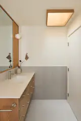 In the hall bath, light gray 12-by-24-inch tile is used for the wainscoting. The skylight, added during the renovation, is finished in the same white oak used throughout the home.