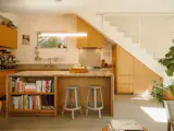 The Queue pendant above the kitchen island is by RBW. The stairs and railing, custom designed by Isaac and Sydney, maintain an open feel.