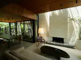 The interiors were conceived as a series of interconnected spaces that allow for flexible use while opening onto patios and terraces. Exposed polished concrete floors, kiri wood ceilings, and other natural materials help bridge indoor and outdoor areas. The stone hearth was brought from the central region of Córdoba, where a local artisan cut and chiseled it by hand.