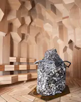 The ceiling has a stalagmite-like texture of alder and heartwood pine, mimicking the crystal pattern of the exterior.