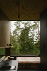 A nearly full-height, wall-to-wall window in the bedroom immerses the cabin in the setting.