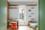 The guest room has floating shelves, and extendable desk, and a pull-out bed with a row of drawers. It steps out onto a terrace with a sauna.