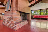 <span style="font-family: Theinhardt, -apple-system, BlinkMacSystemFont, "Segoe UI", Roboto, Oxygen-Sans, Ubuntu, Cantarell, "Helvetica Neue", sans-serif;">Like in many of Frank Lloyd Wright’s designs, the house has a large fireplace anchoring the living space.</span>