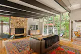 The living room has one of the home’s two woodburning stone fireplaces.