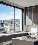In clear mode, CLiC brings the surrounding landscape into the kitchen, and the natural light adds dimension to this home’s stone and dark cabinetry.