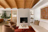Exposed post-and-beam construction, a vaulted wood ceiling, and clerestory windows bring height and daylight to the open kitchen, dining, and living areas, which are unified by polished concrete floors.