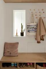 Just inside the ground-floor entry, the hallway incorporates built-in storage, coat hooks, and a small seating nook.