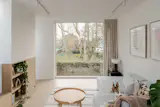 At the top of the custom solid-oak staircase, a floor-to-ceiling window opens the second-floor living room to views across Butterfield Green.