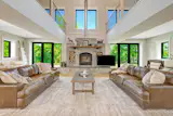 The living room has a massive stone fireplace, a 30-foot vaulted ceiling, and glass doors that open to the outdoors.&nbsp;&nbsp;