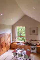 <a href="https://www.furloughwoodco.com/">Ally</a> designed and fabricated the mosaiclike cabinet fronts and carved appliance pulls as well as all the kitchen millwork. <span style="font-family: Theinhardt, -apple-system, BlinkMacSystemFont, "Segoe UI", Roboto, Oxygen-Sans, Ubuntu, Cantarell, "Helvetica Neue", sans-serif;">The backsplash was made by Sarah Gilbert of <a href="http://instagram.com/lodestone.alternative.building">Lodestone Alternative Building</a>. The solid white oak flooring is from <a href="http://almanachardwood.com">Almanac Hardwood</a>. The induction range and DishDrawer are from <a href="http://fisherpaykel.com">Fisher & Paykel</a>. The farmhouse sink is from <a href="http://kohler.com">Kohler</a>. The Odin faucet is from <a href="http://brizo.com/">Brizo’s</a> Jason Wu collection. The ceramic sculpture above the stove is by <a href="http://instagram.com/graduationboy69">Harry Kuttner</a>. The small framed artwork is by <a href="http://eileenechikson.com">Eileen Echikson</a> and <a href="http://instagram.com/patrick_____david">Patrick David</a>.</span>