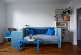 Catherine built the couch and the desk using plywood, and then she applied a light coat of blue paint to preserve the wood grain.