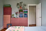 Catherine coated a mix of dressers in shades of red and pink, then painted her bedroom a light blue to tie the colors together.