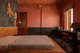 In son Nithin’s bedroom, red and black tones of oxide plaster mix with muted neutral linens. The wall light is from Light Art Studio and the pendant is from Fab India.