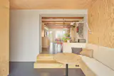 Facha used natural linoleum flooring throughout the renovation. An opening connecting the addition to the original home creates sightlines through the home.