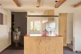 A woodburning stove supplements a new air-to-water heat pump, and provides ambiance in the small space.