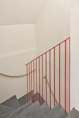 The stairs leading up to the bedrooms were resurfaced and a red railing was added.