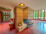 A full-height block fireplace anchors the main living area, helping define the entry, living room, and dining space.