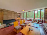 The roughly 2,500-square-foot house stretches out in a low, linear plan, with the main living spaces and bedroom wing organized along a central gallery.