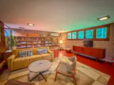 At the opposite end of the plan, a second living space originally designed as a general-purpose room is raised a few steps above the adjoining spaces.