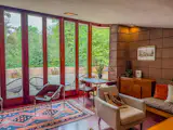 Ten-foot tall windows line the living room, bringing in views of the surrounding woods.