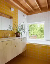 The kids’ bathroom has a cheerful combination of white and yellow square tiles.
