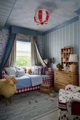The wallpaper in this children’s bedroom is Schumacher’s Beasts; the designers said they hoped the clouds on the ceiling inspired an adult to use the paper in their own room. The light fixture cover is from Tulip.
