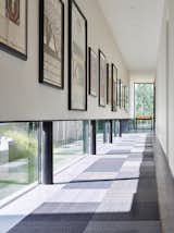 An art gallery was designed with low windows to allow natural light to permeate while protecting the sensitive art from harmful direct sunlight. It is these careful details that, in combination with the striking lineation of the home, create a harmonious alliance of function and design.