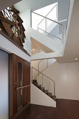 Inside, a ledge above the door holds an antique water wheel, a notable piece belonging to the Client.  This wheel is backlit with a large window adjacent to it.  Top floor skylights add dramatic light which filters down a multi-tiered staircase.    