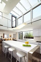 The central two-story kitchen is washed with light from multiple skylights, which also filter into the adjoining living and dining rooms.