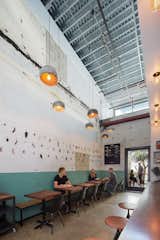The interiors of the repurposed car bays show their industrial background.  This taco bar, also designed by Abramson Teiger Architects, has raw cinder block on the walls leftover from its car repair roots. 
