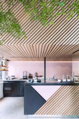 Designed by Standard Studio, the graphic store uses a palette of black and pink powder-coated metal and diagonally aligned wood slats. Photo by Wouter van der Sar.