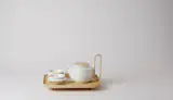 The product, produced by centuries-old Japanese porcelain maker Kihara Ceramics, includes a pot, strainer, and two bowls. (The Sucabaruca tray, also by the two designers, is pictured with the set.)
