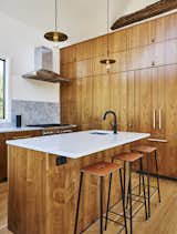 European walnut lines the custom kitchen, which is outfitted with Blum and Hafele hardware, a Brizo faucet, and pendants by Danish studio Frama. The range is Thermador.