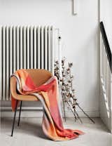 LOOM blanket by Swedish textile artist Simon Key Bertman draped over the Fiber Armchair by Copenhagen-based design duo Iskos Berlin; Photo courtesy of Muuto. 
